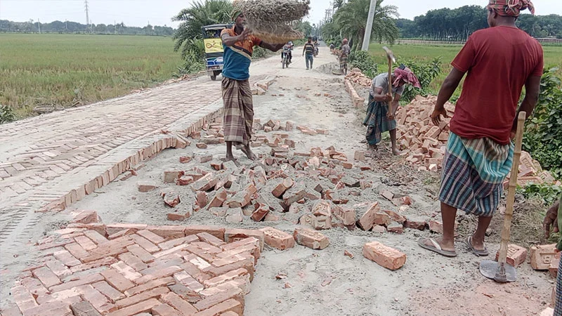 Brick paving is being laid by digging up a pitched road